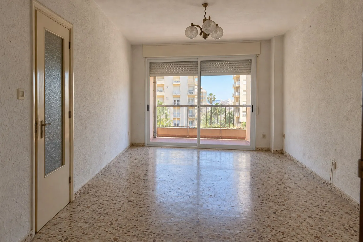 Salón de piso en Playamar, Torremolinos, con terrazo y paredes de gotelé antes de la reforma