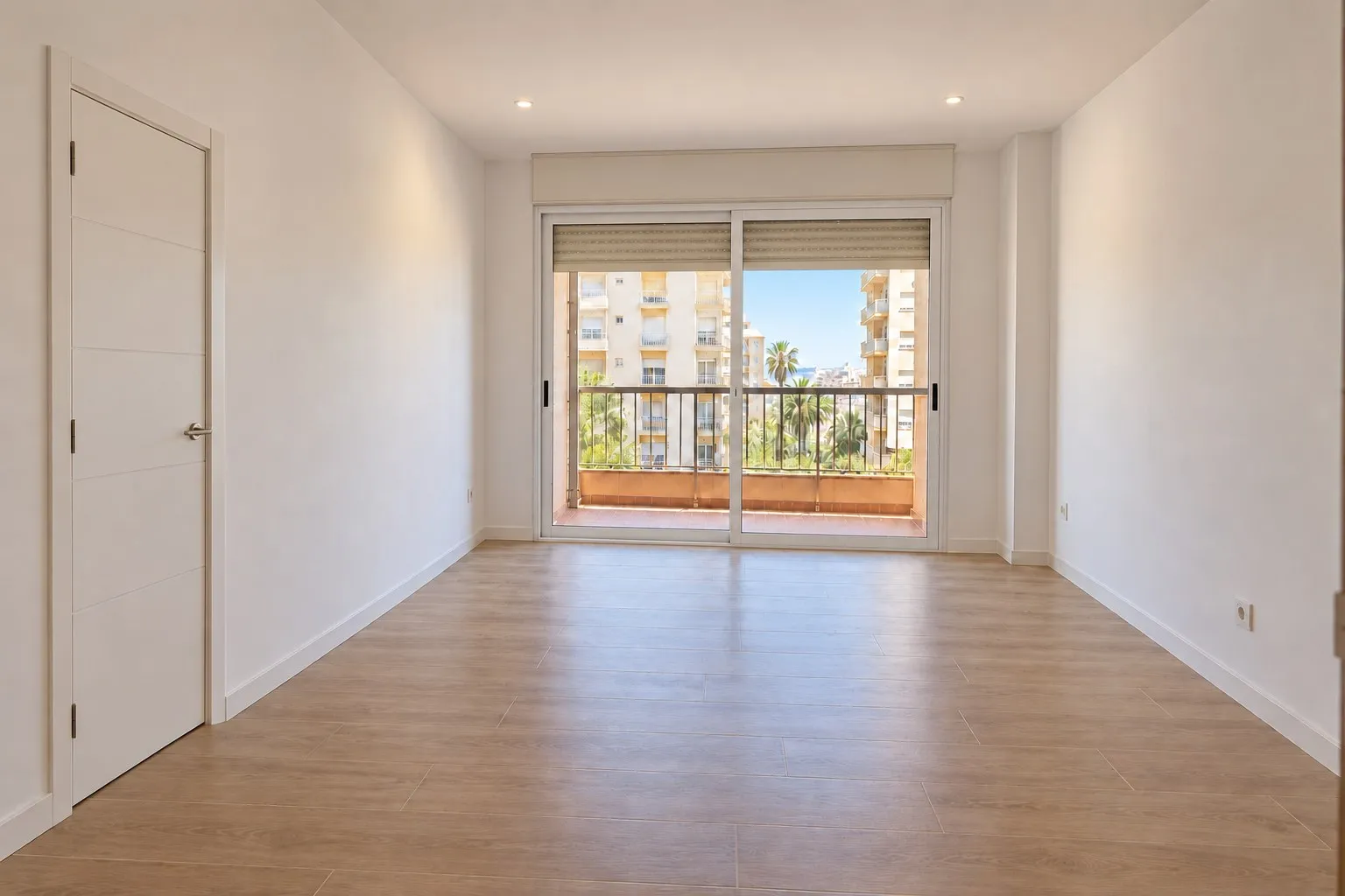Salón de piso en Playamar, Torremolinos, con suelo laminado y paredes lisas después de la reforma